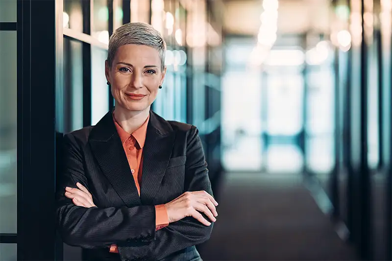 Law firm professional with arms crossed standing in office