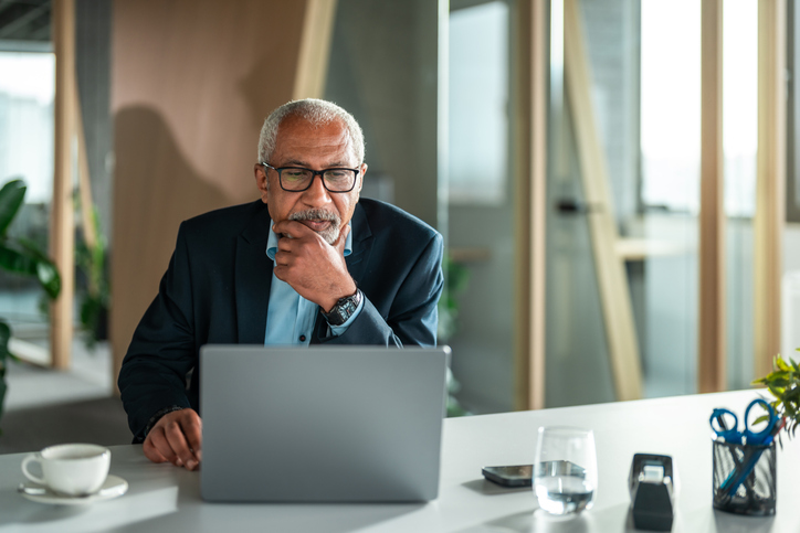 Diverse Senior Executive Ponders Business Strategy in Office