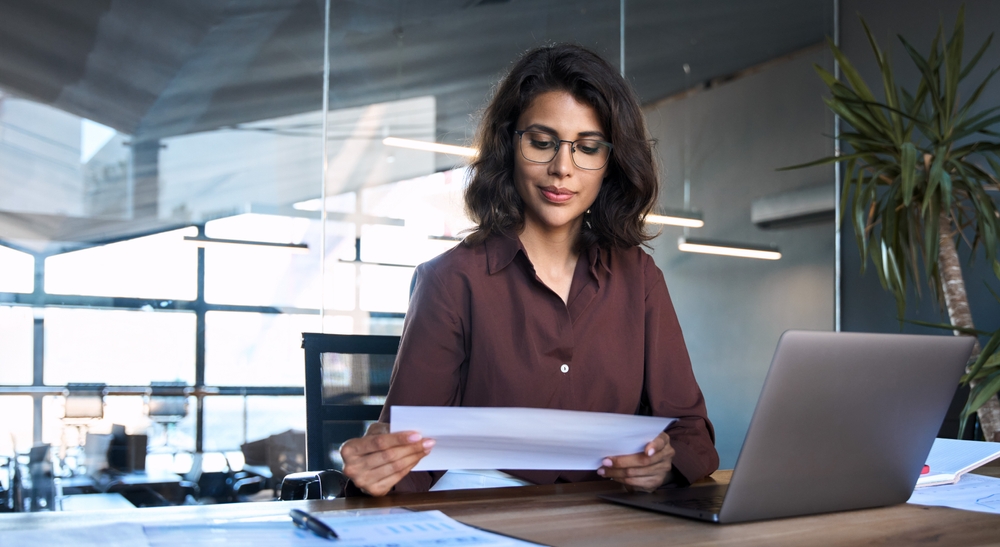 Woman reviewing document at a laptop