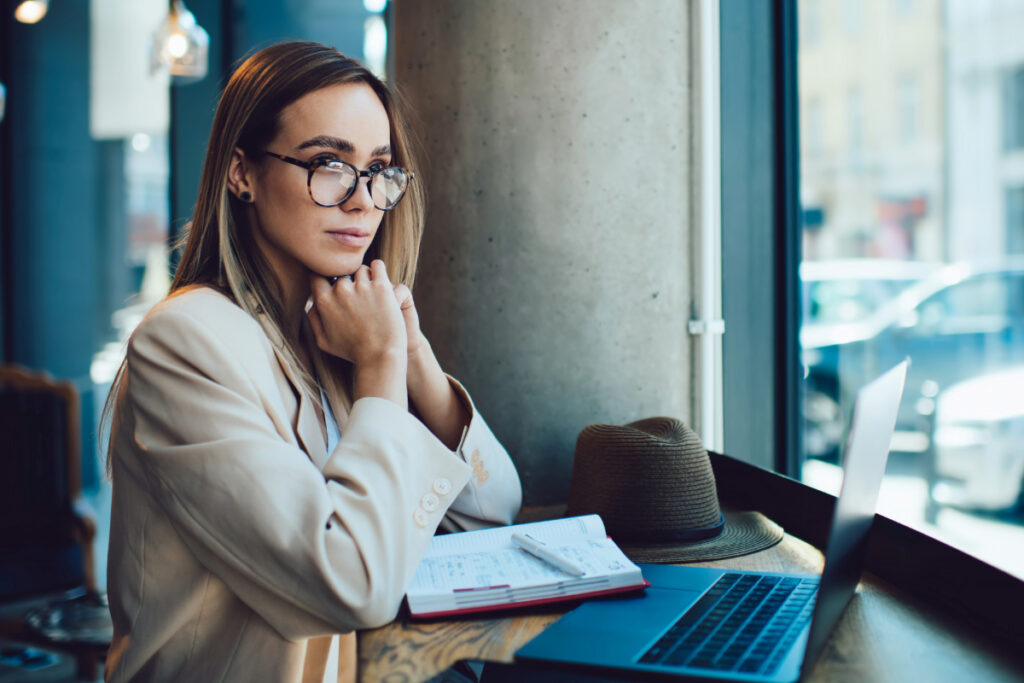 Professional sitting in front of a laptop thinking