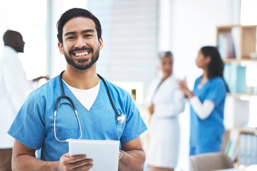 Doctor in scrubs holding tablet