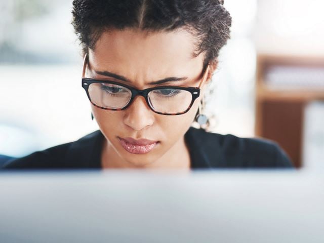 Frau schaut besorgt auf den Computerbildschirm