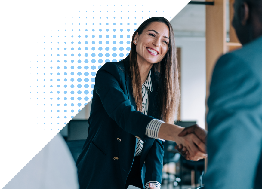 Two people in business attire smile and shake hands