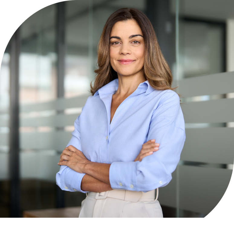 Een vrouw kruist haar armen en glimlacht, terwijl ze recht in de camera kijkt