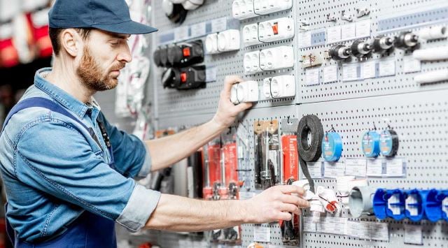 man looking at a wall of hardware supplies