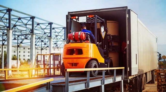 Vehicle loading boxes onto a semi truck