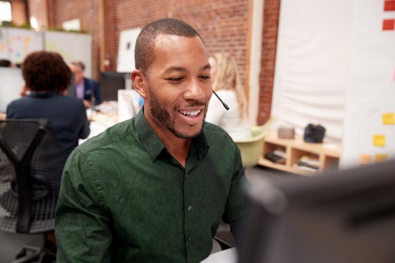 Man in a busy office environment wearing a headset