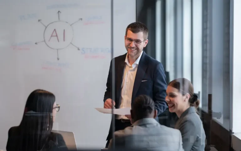 young professional talking to colleagues in front of whiteboard saying AI