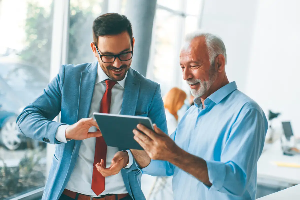 Two colleagues looking at tablet together and smiling