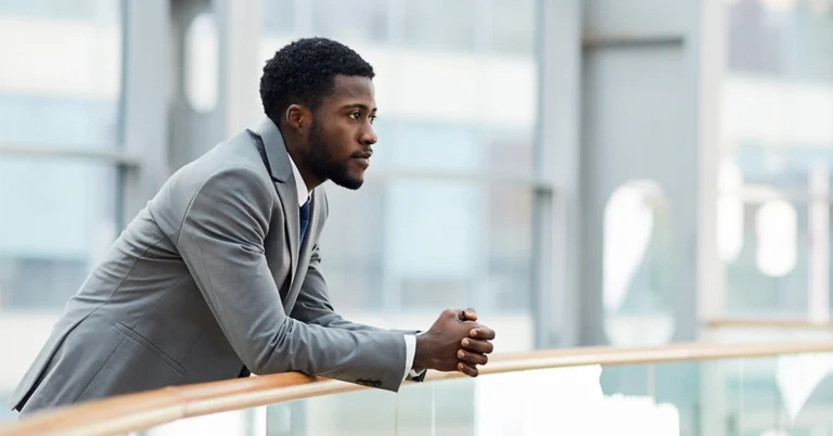Thoughtful businessman leaning on railing
