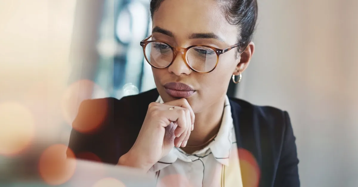 women wearing classes looking at computer thinking