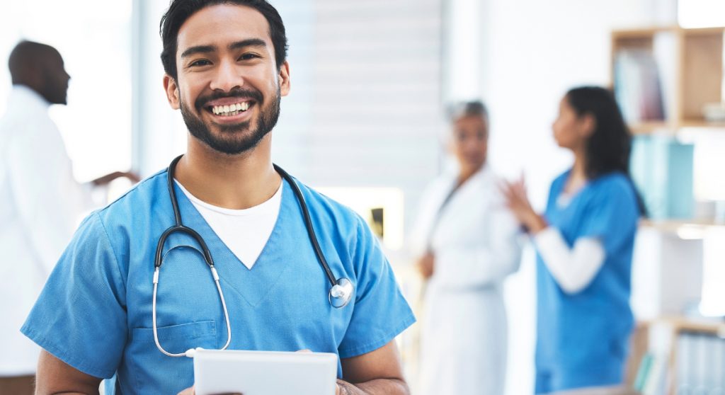 Doctor in scrubs holding tablet