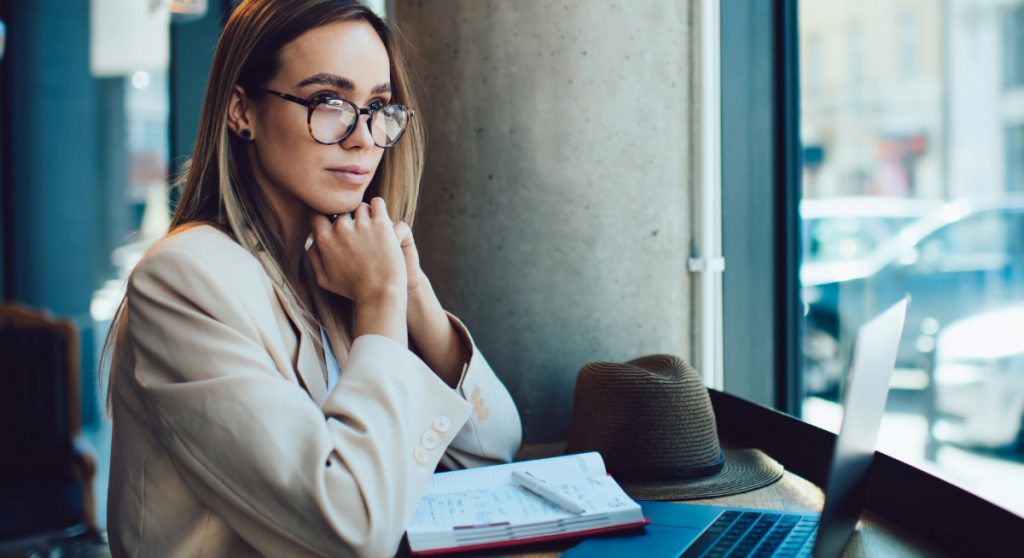 Professional sitting in front of a laptop thinking