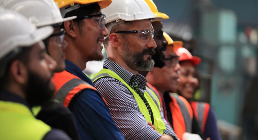 Row of diverse factory workers posing for the camera