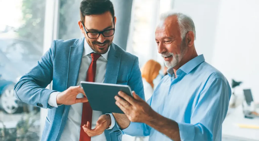 Two colleagues looking at tablet together and smiling