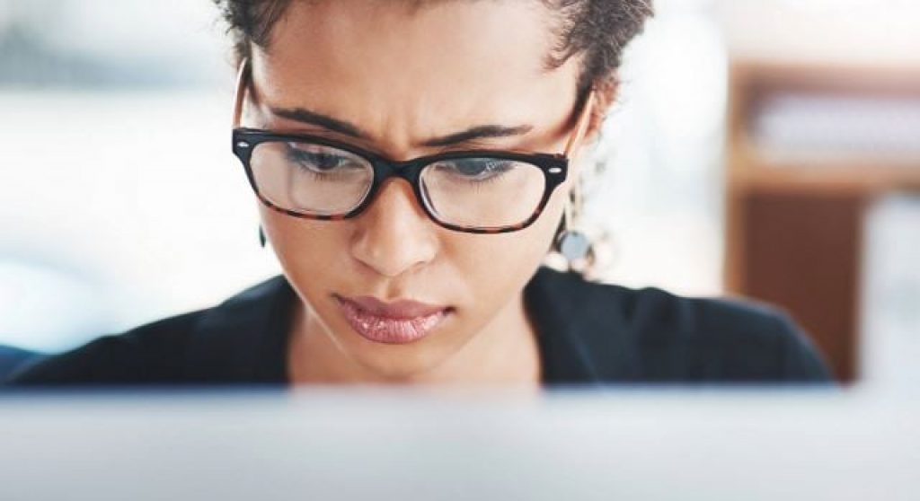 Frau schaut besorgt auf den Computerbildschirm