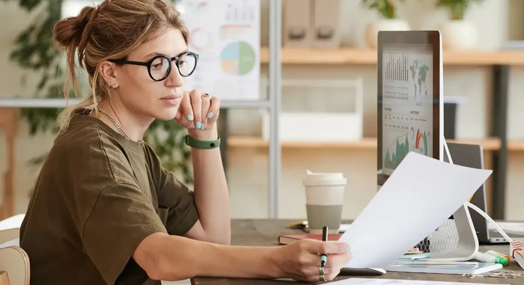 Young professional woman looking at invoice