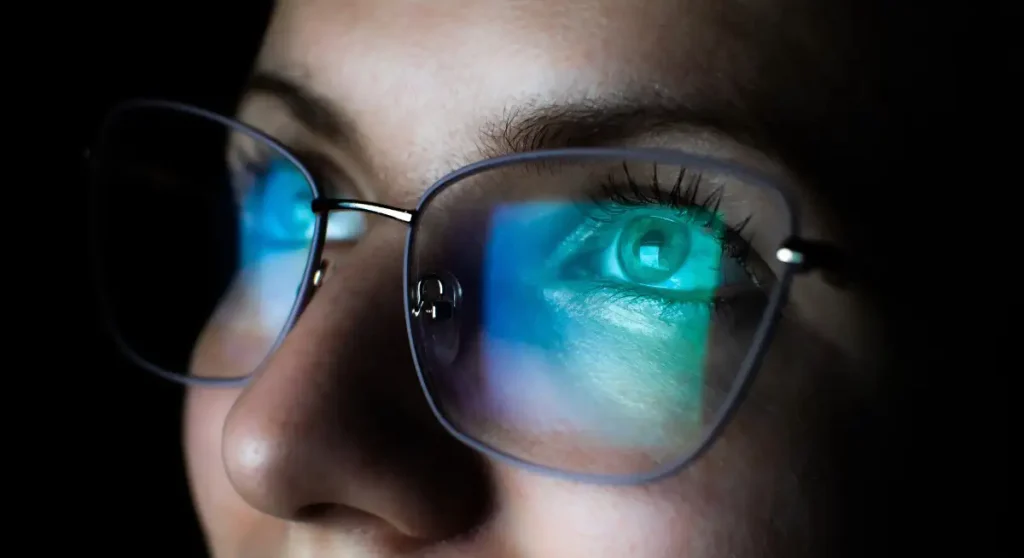 computer screen reflected in woman's glasses
