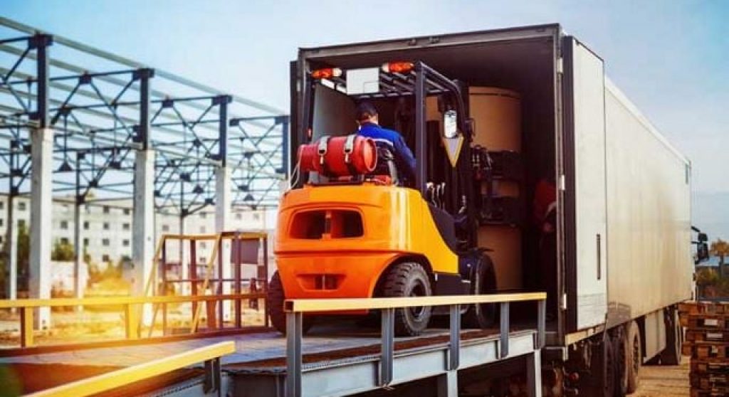 Vorkheftruck laadt dozen in een vrachtwagen