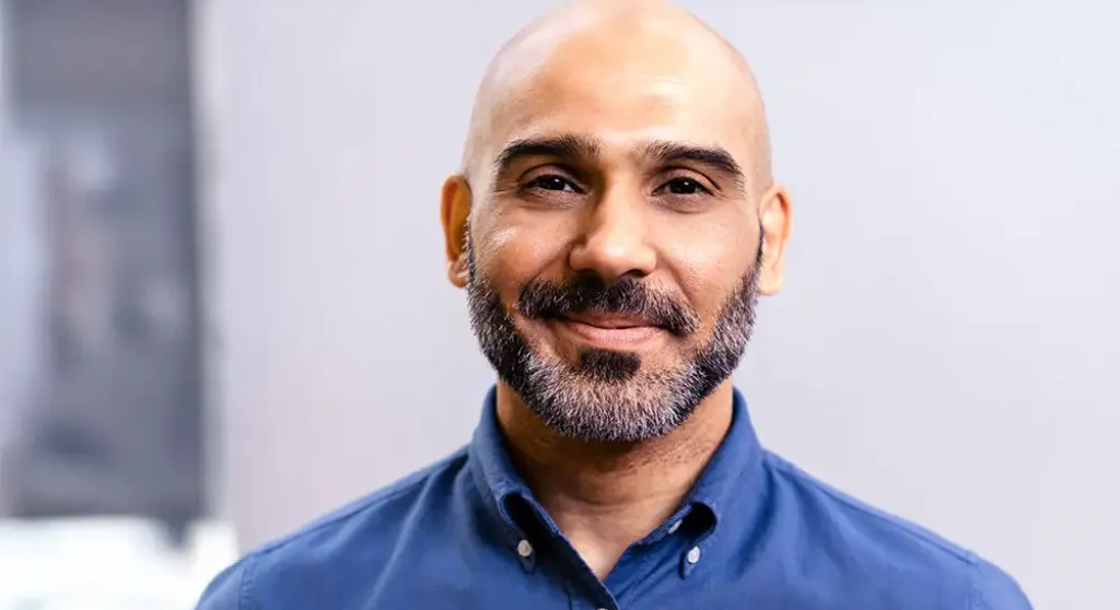 professional bearded man smiling at camera in office