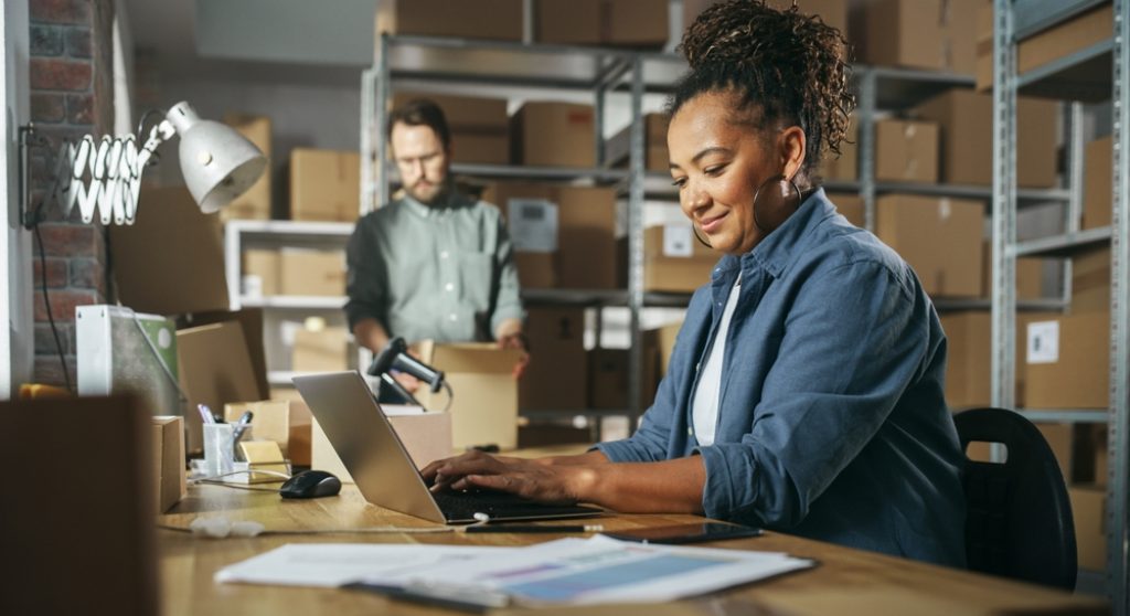 Employee using laptop in a warehouse