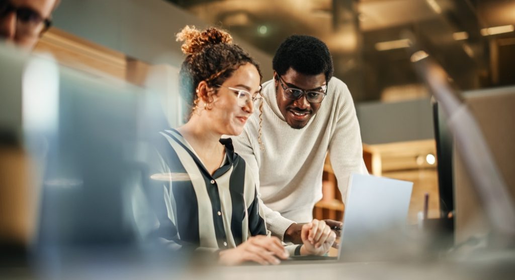 Two colleagues working at computer together