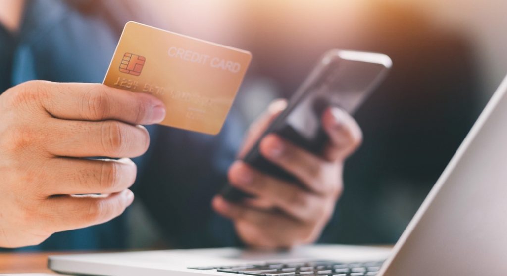 Hands holding credit card and phone
