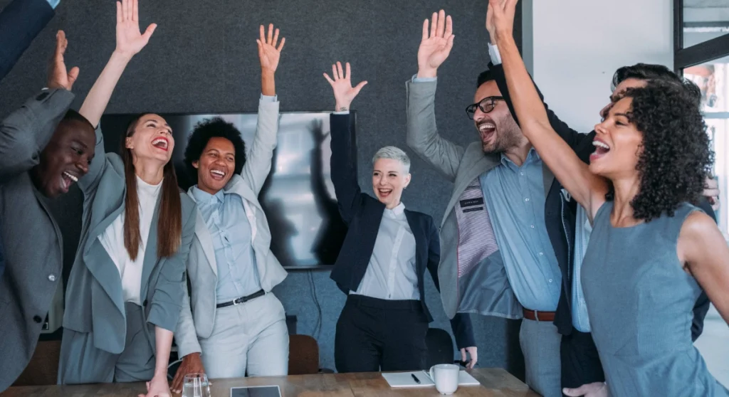 Team celebrating with hands in air