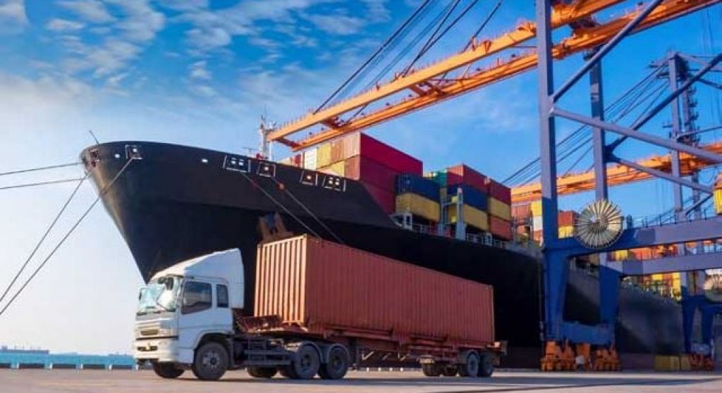 Containerschip en verschepende vrachtwagen bij een haven