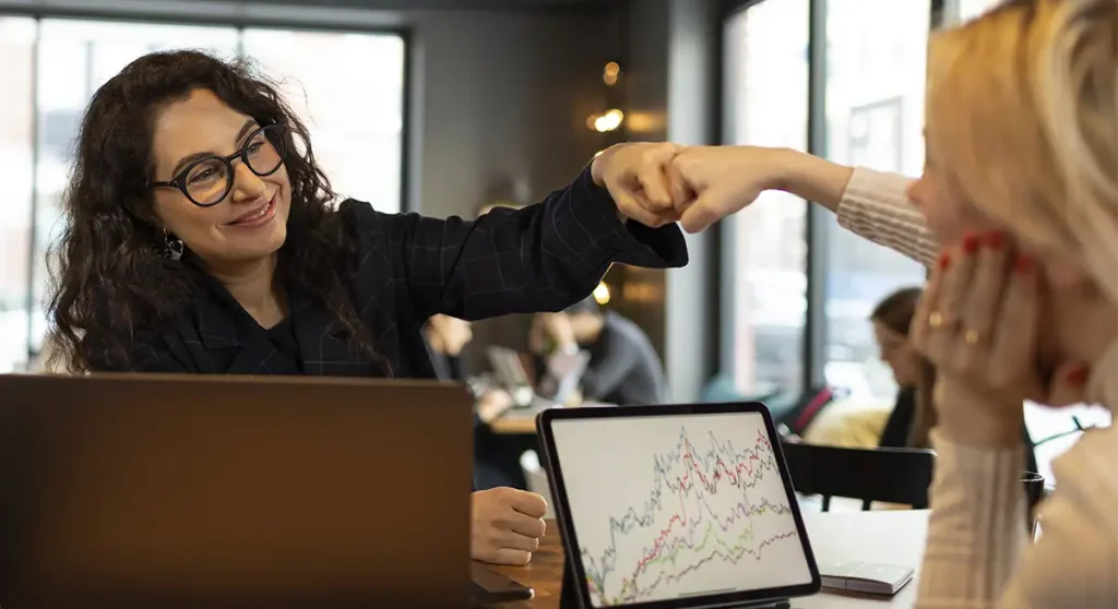young professional leader fist bumping her teammate